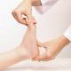 Examination of a child by an orthopedist. Cropped shot of female doctor holding a kid's foot in her hands.Pathology of bone structures, flat feet, injury. Foot treatment. Pain from uncomfortable shoes